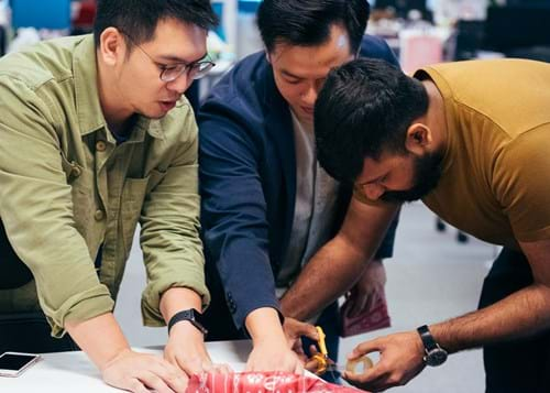 Three WE employees wrapping gifts