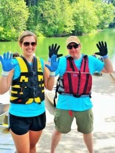 Two WE volunteers smile while cleaning up a river