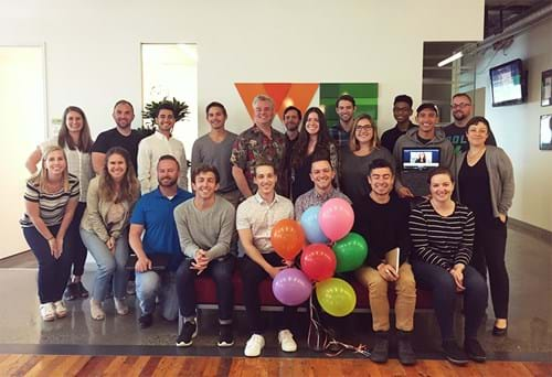 large group photo of WE employees with rainbow pride balloons