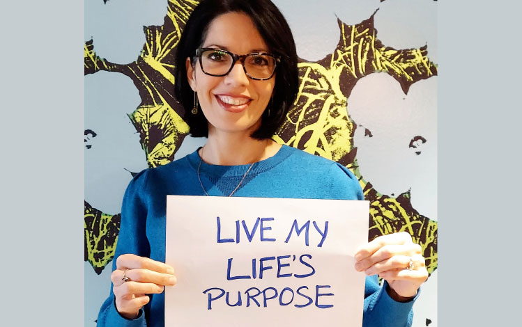 woman holding sign saying live my lifes purpose