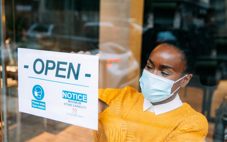 woman putting open sign on door